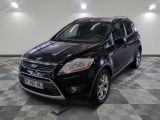 La Ford Kuga noire est garée sur un sol en carrelage à damier.