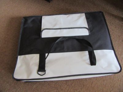 un sac noir et blanc posé par terre à côté d'une chaise