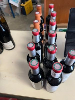 plusieurs bouteilles de vin posées sur une table à côté d'un téléphone portable