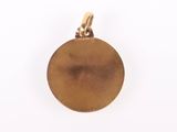 a close up of a gold pendant on a white background