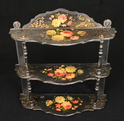 une étagère noire ornée de fleurs, sur fond noir