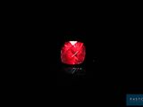 a close up of a red diamond on a black surface