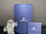 une figurine en verre posée à côté d'une boîte bleue