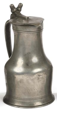 a silver pitcher sitting on a white surface