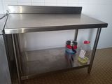 une table de travail en acier inoxydable équipée d'un évier et d'un lave-vaisselle
