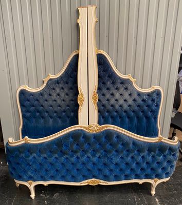 an image of a blue and white bed with gold trim