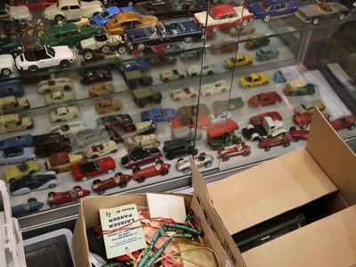 une boîte remplie de petites voitures exposée dans une vitrine