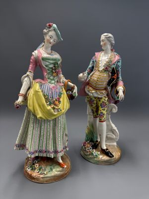 deux figurines représentant un homme et une femme vêtus de costumes d'époque