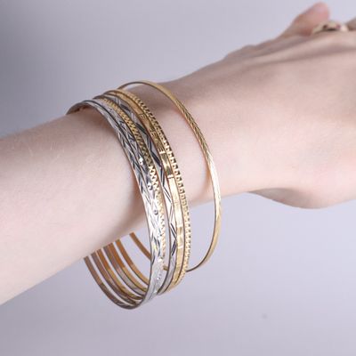 le bras d'une femme sur lequel sont enfilés trois bracelets différents