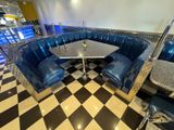 a photo of a diner booth with blue booths and black and white checkered flooring