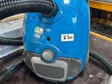 un aspirateur bleu posé sur une table