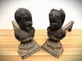 two statues of a boy and a girl on a wooden table
