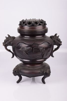 une image représentant un vase en bronze posé sur une surface blanche