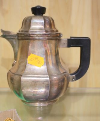 une théière en argent posée sur une table en verre