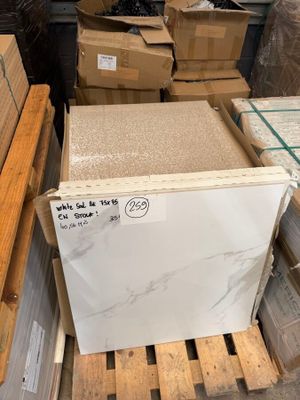 a pile of white marble slabs in a warehouse with pallets