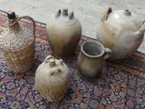 quatre vases posés sur un tapis, à même le sol