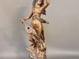 statue en bronze d'une femme tenant un oiseau sur un piédestal