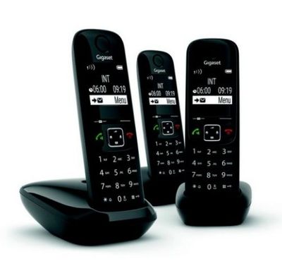three black phones sitting on top of each other on a white surface