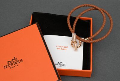 an orange box with a necklace and a card inside of it