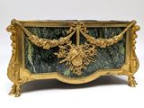 a gold and green marble box with a bird on it