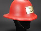 a close up of a red fireman ' s helmet on a mannequin head