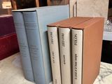 several books are stacked on a marble table in a library