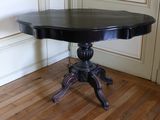 une table noire avec un plateau noir posée sur un sol en bois