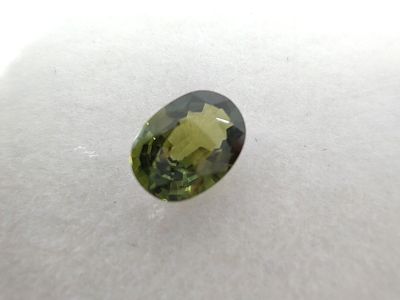 a close up of a green tourmaline stone on a white surface