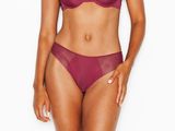 La femme en bikini violet prend la pose devant l'appareil photo.
