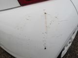 a white car with rust on the hood of it