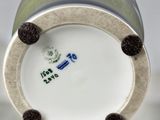 a close up of a white vase with a blue and green design