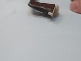 a person holding a piece of paper with a hairbrush on it