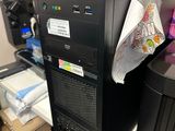 un ordinateur noir posé sur un bureau dans un coin de la pièce