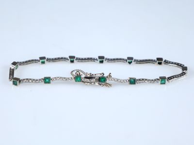 un bracelet orné d'émeraudes et de diamants sur fond blanc