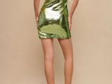 the back of a woman wearing a green dress and blue shoes