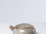 un vase blanc et marron posé sur une table blanche
