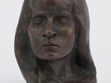 un gros plan sur la tête d'une statue de femme posée sur une surface blanche
