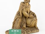 a statue of a man sitting on a rock next to a credit card