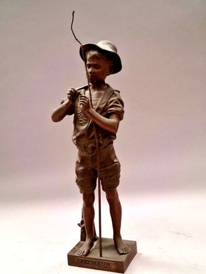 statue en bronze représentant un garçon avec un chapeau et une canne