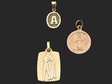 three gold pendants of a woman and a medal on a black background