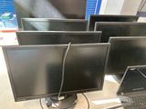 three computer monitors and a laptop on a desk in a room