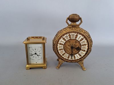 une petite horloge en or à côté d'une autre horloge en or, plus petite