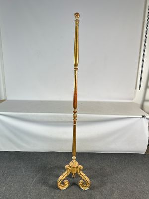 un lampadaire ancien en laiton et en bois trône sur un sol recouvert de moquette