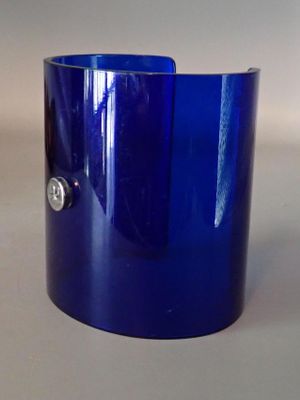 a blue glass bracelet with a silver button on it