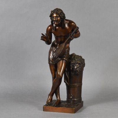 a bronze statue of a man holding a bucket of grapes