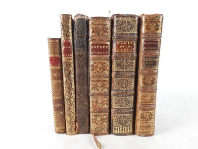 several old books are stacked on top of each other on a white surface