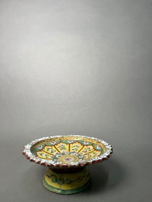 a yellow and green bowl sitting on top of a table