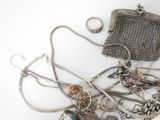 a lot of silver jewelry on a white surface