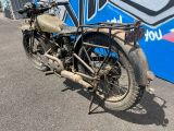 une vieille moto garée devant un mur recouvert de graffitis