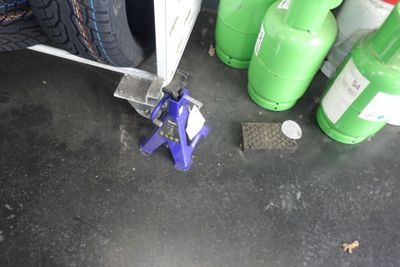 une pince à pneus qui se trouve à côté de quelques bouteilles vertes